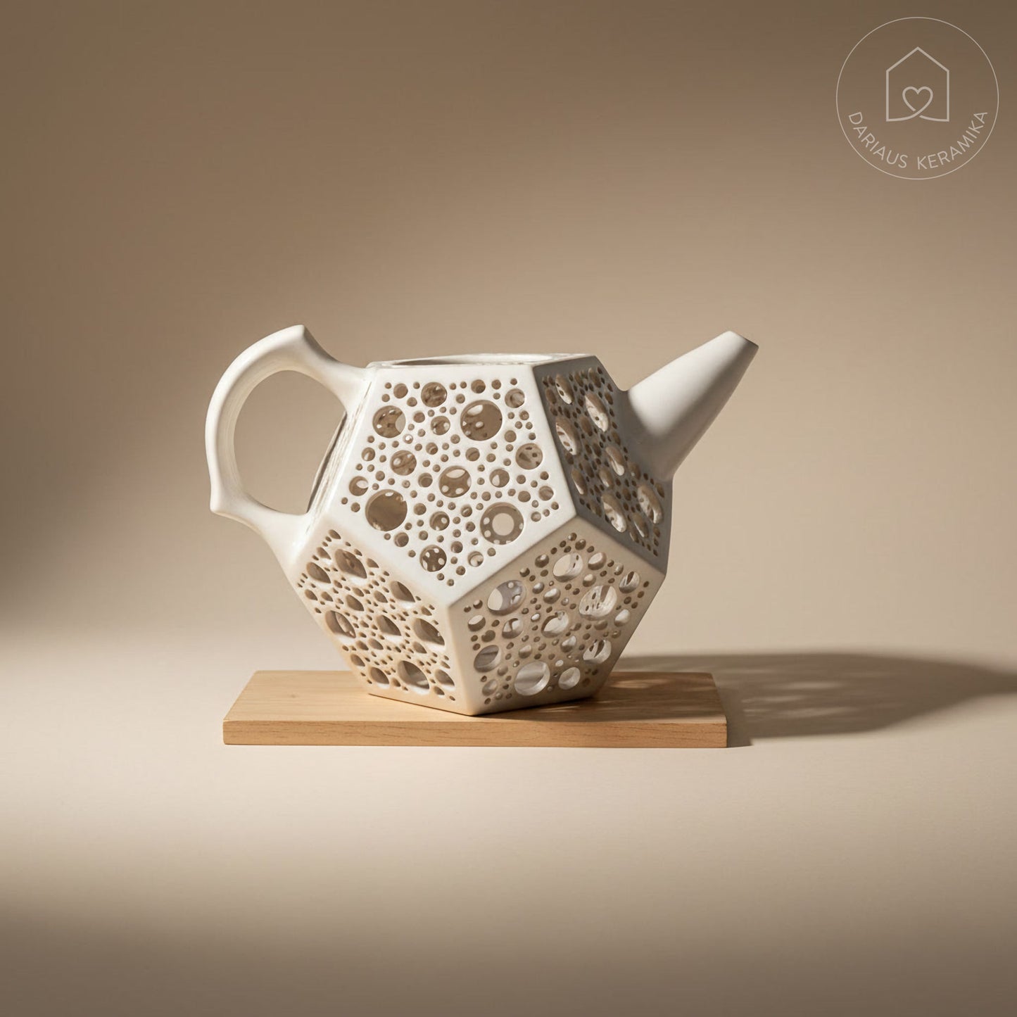 Ažūrinė balta keraminė žvakidė arbatinukas dodekaedro formos skleidžianti šviesą tamsoje ant medinio stalo