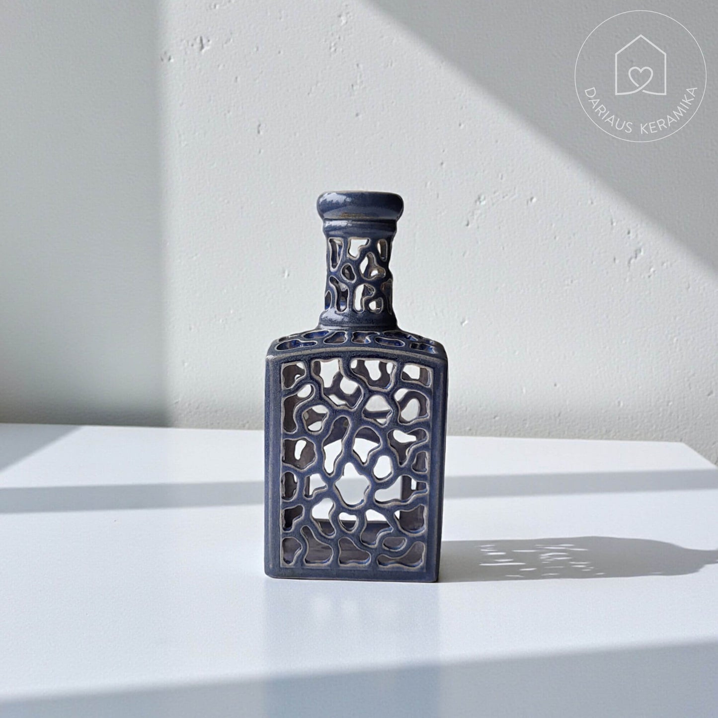 Ažūrinė rankų darbo keraminė žvakidė butelio formos interjerui