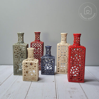 Ažūrinė rankų darbo keraminė žvakidė butelio formos interjerui